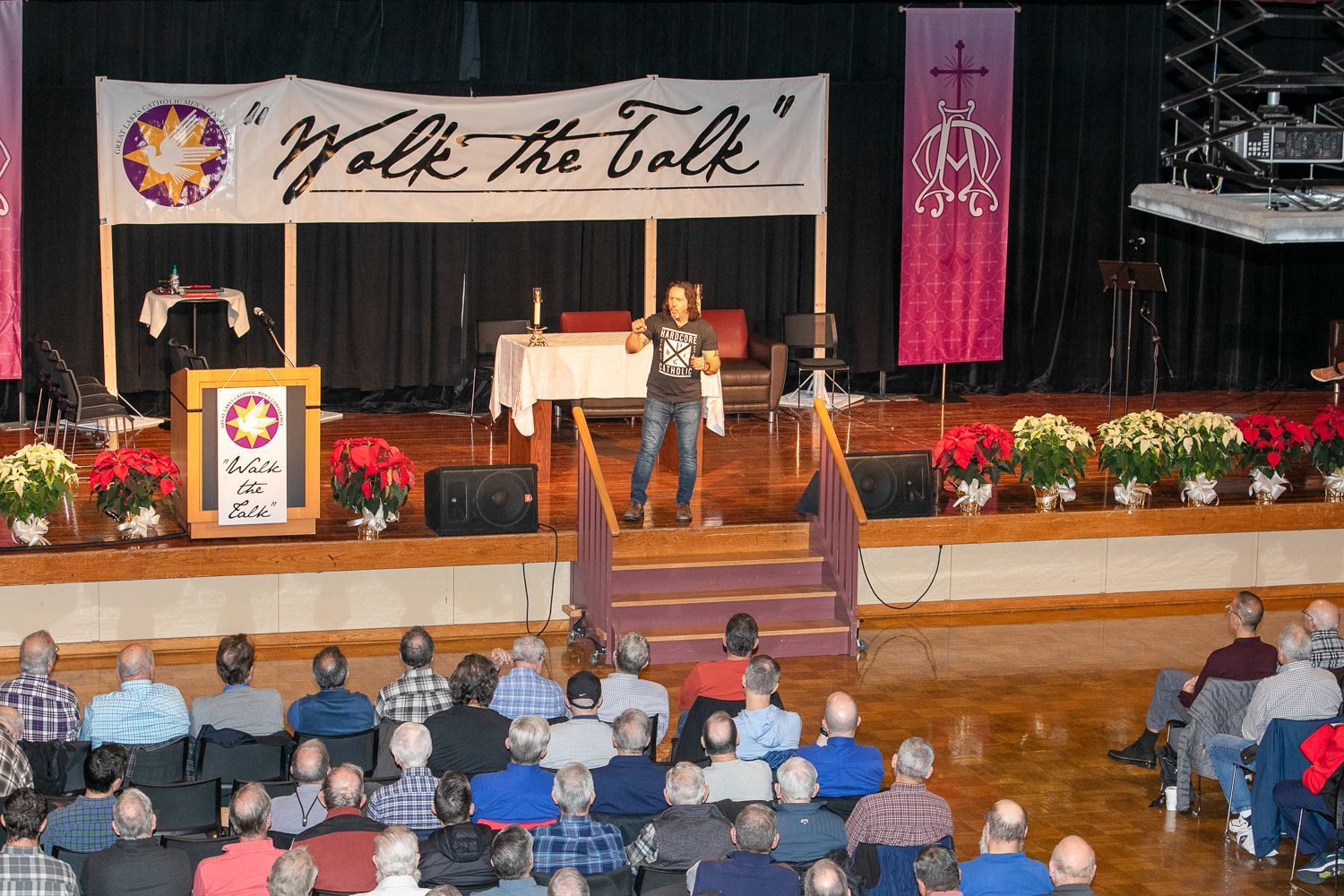 Keith Nester at podium on church stage, with banner reading “We Are the Truth” and seated audience in front