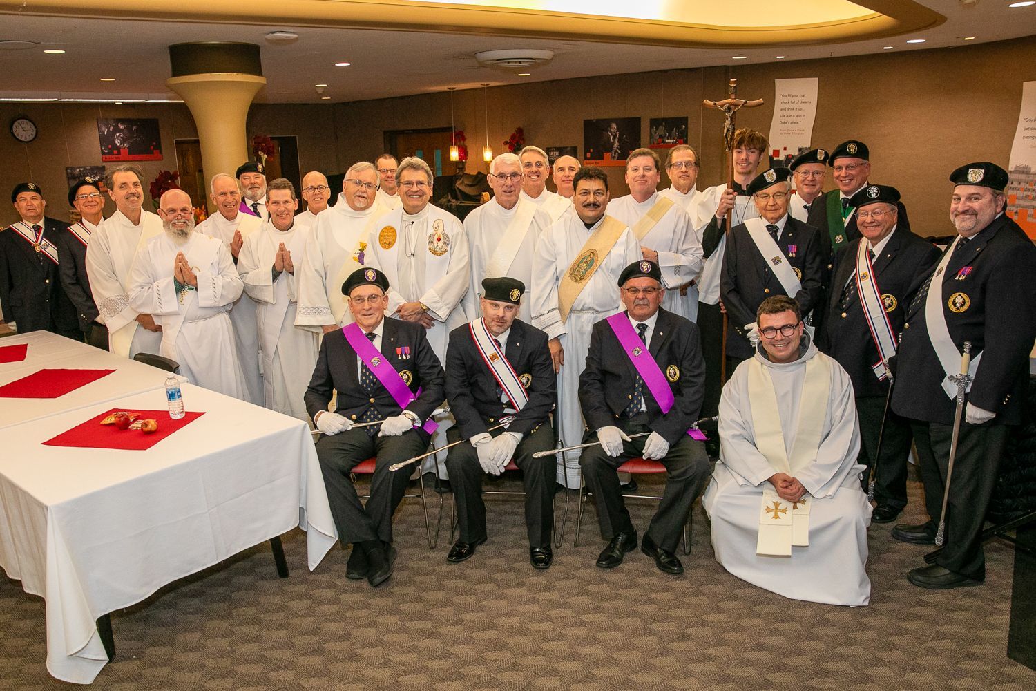 Large group in uniforms and suits posing indoors at an awards ceremony
