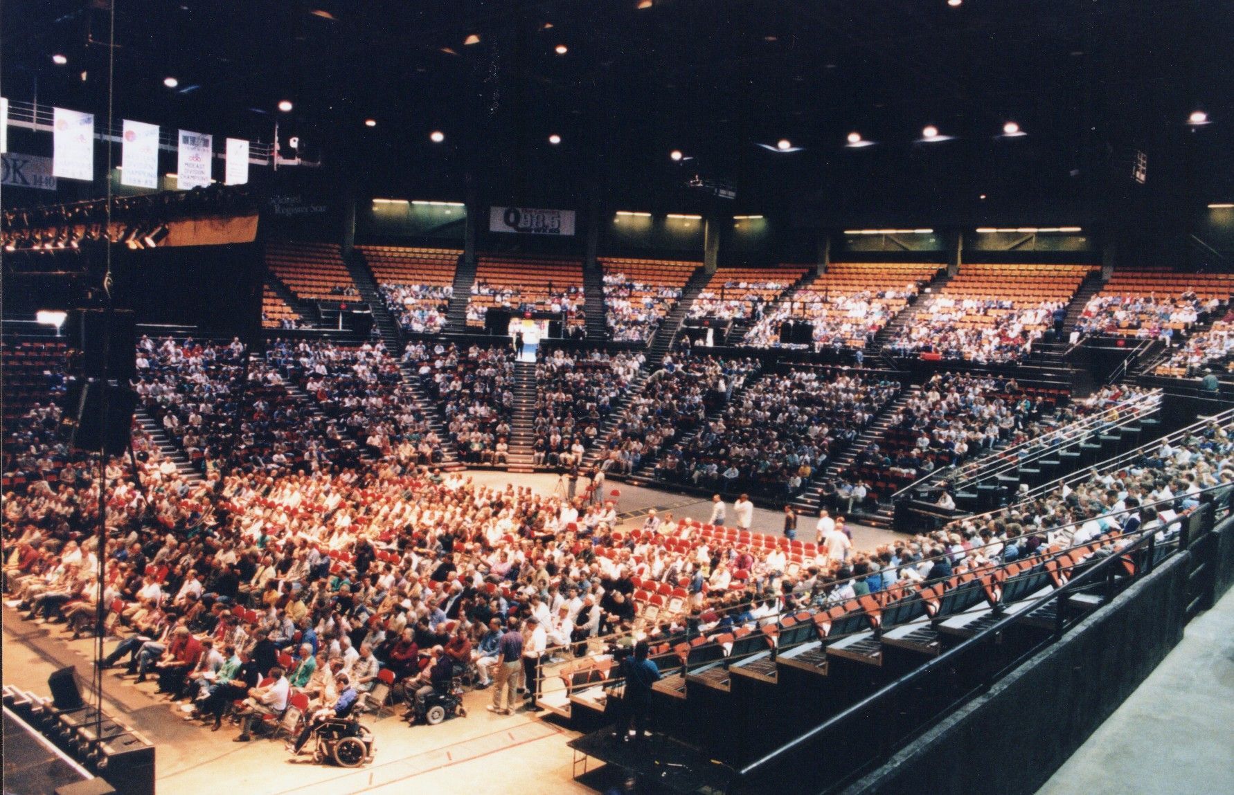 Large indoor arena packed with spectators under bright lights