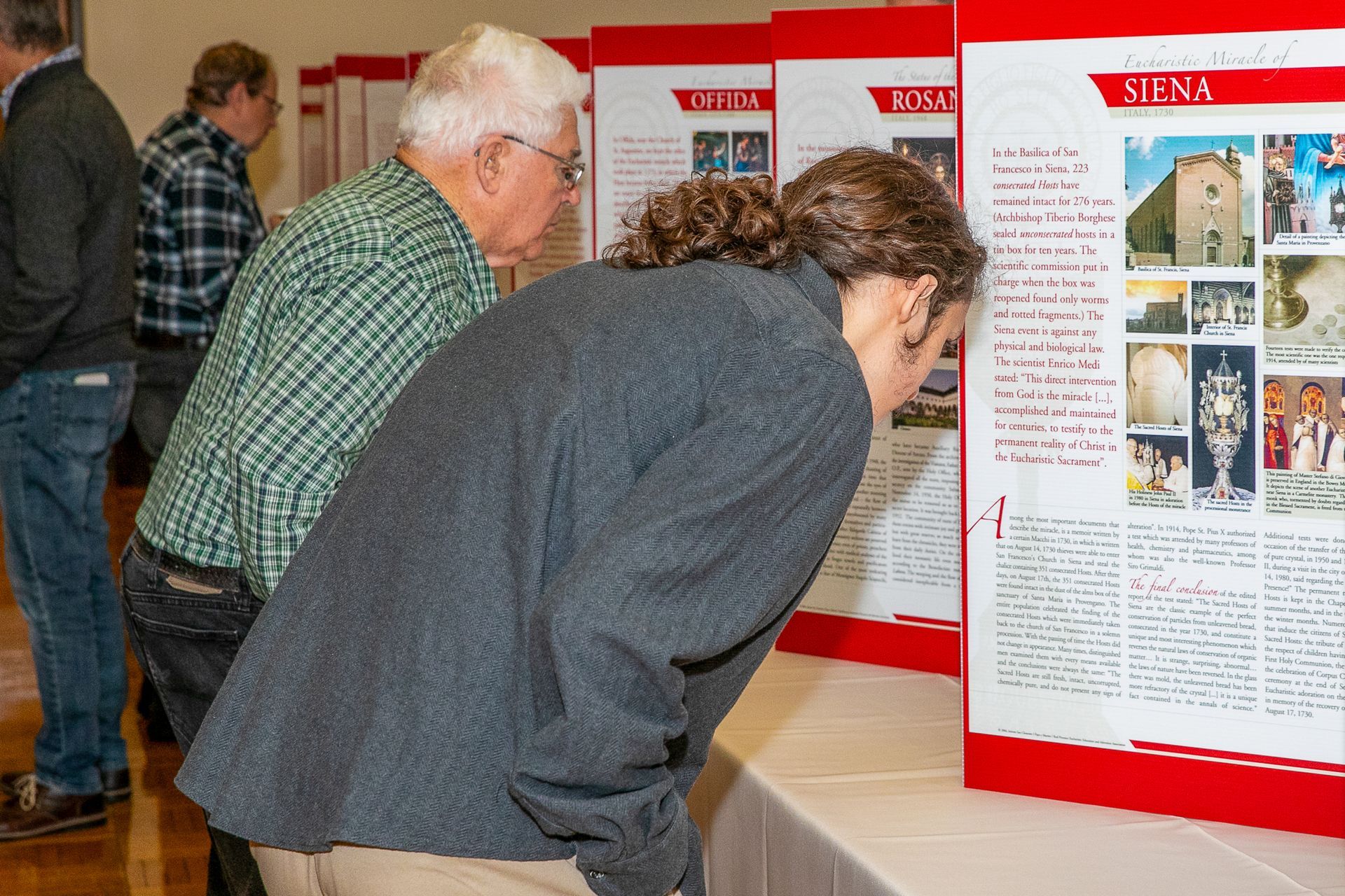 People viewing exhibit posters in a museum or gallery display