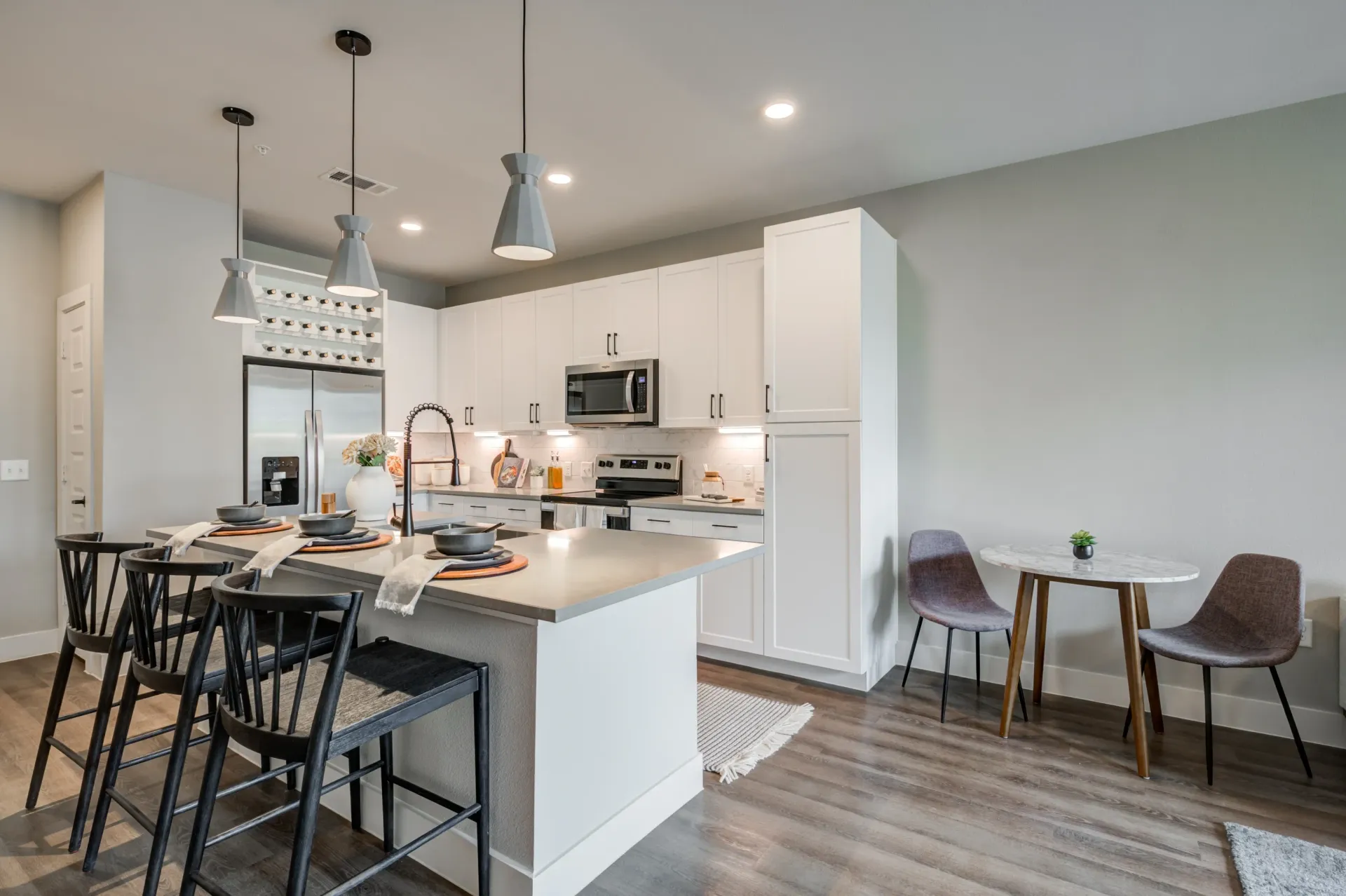 Modern kitchen with white cabinets, stainless steel appliances, and a large island with seating.