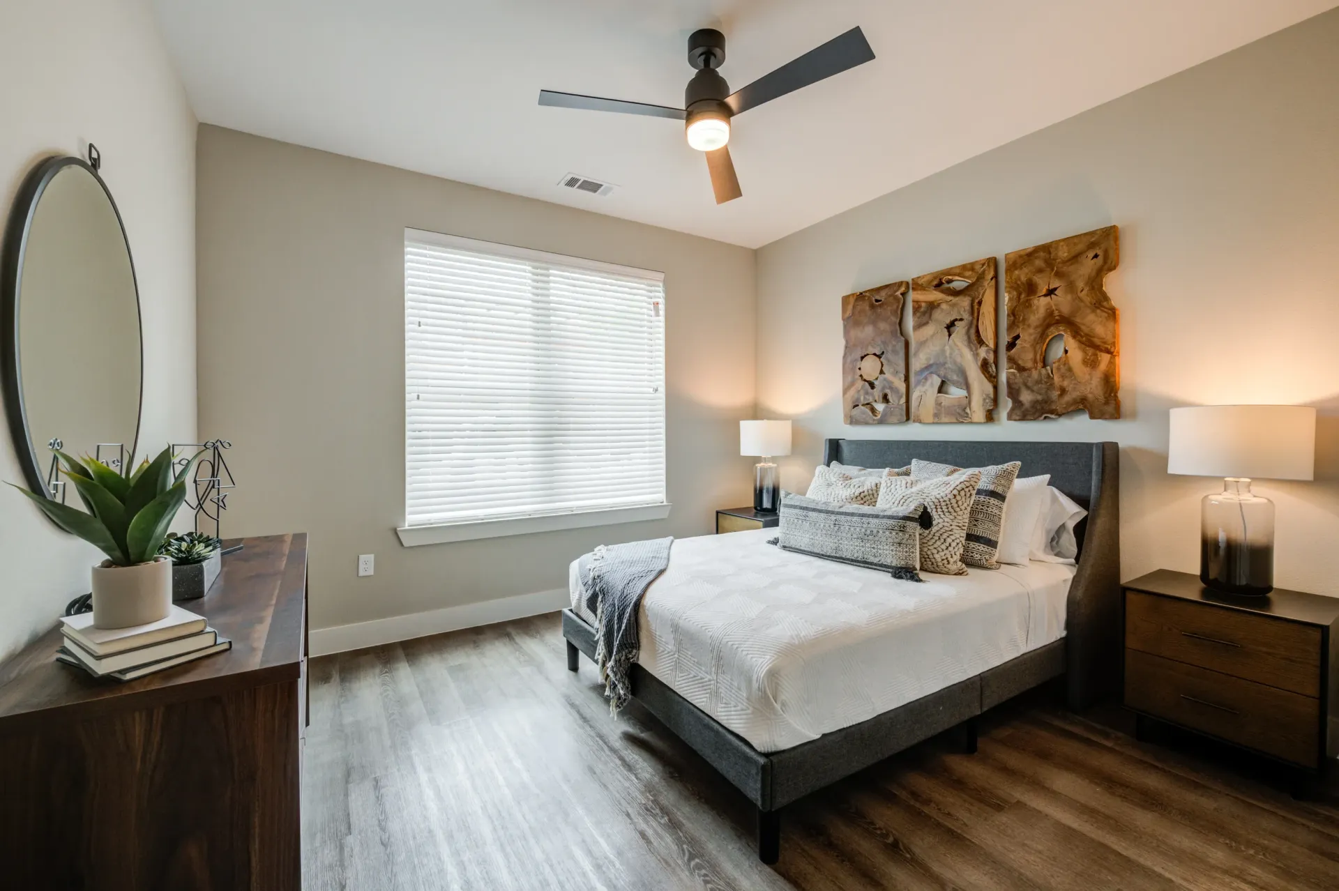Bedroom with a queen-size bed, ceiling fan, dresser, and nightstands.