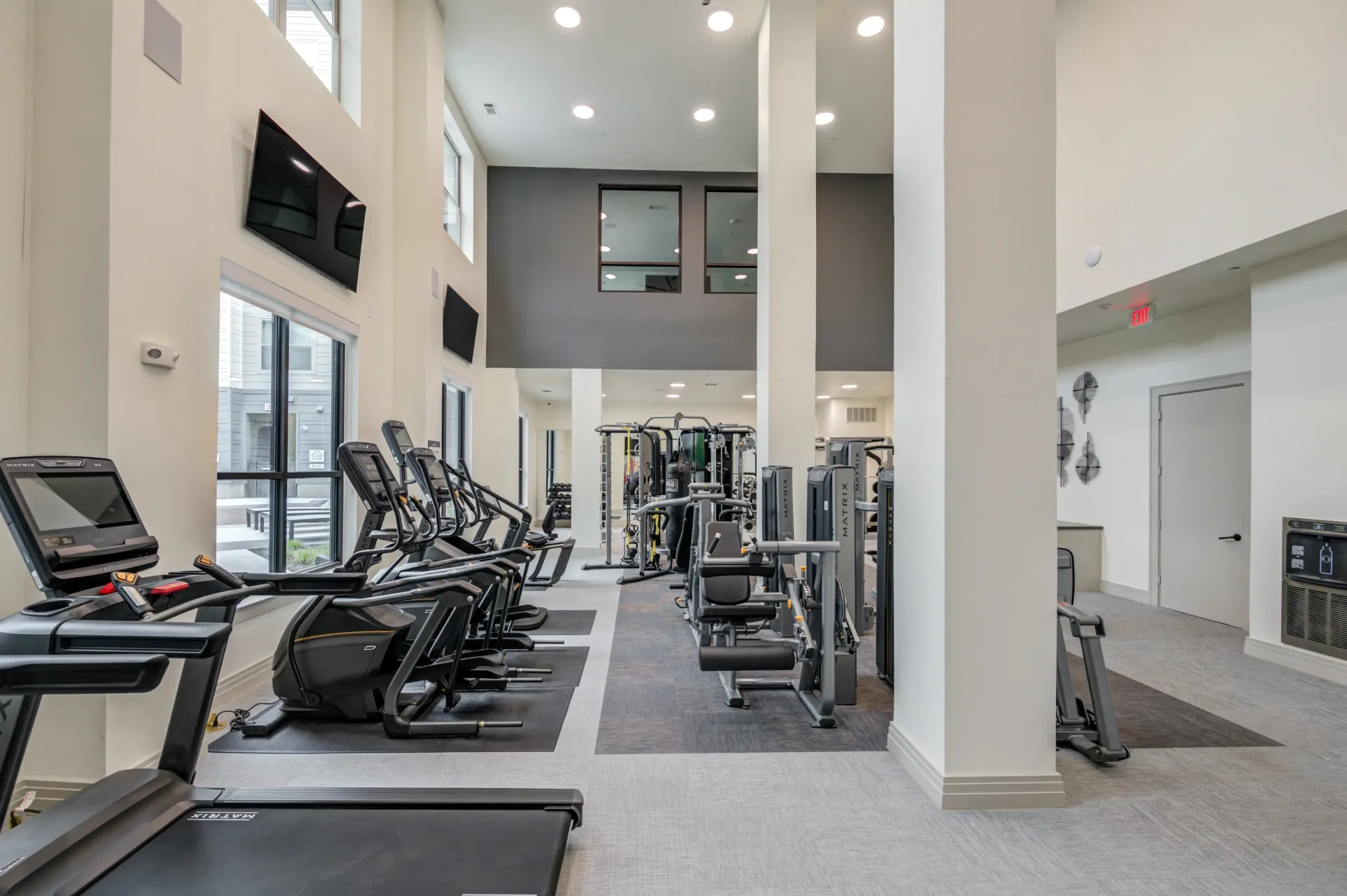 Modern apartment fitness center with cardio machines and weight equipment.