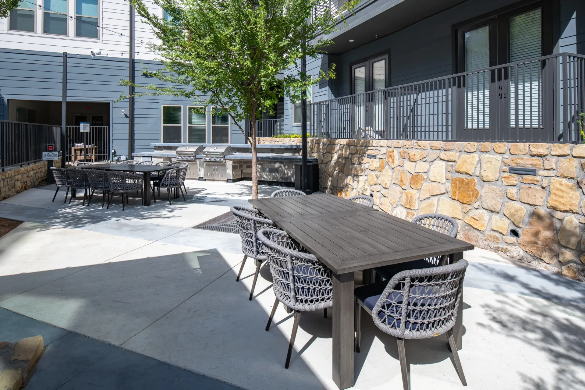 Outdoor patio with dining tables and grills.