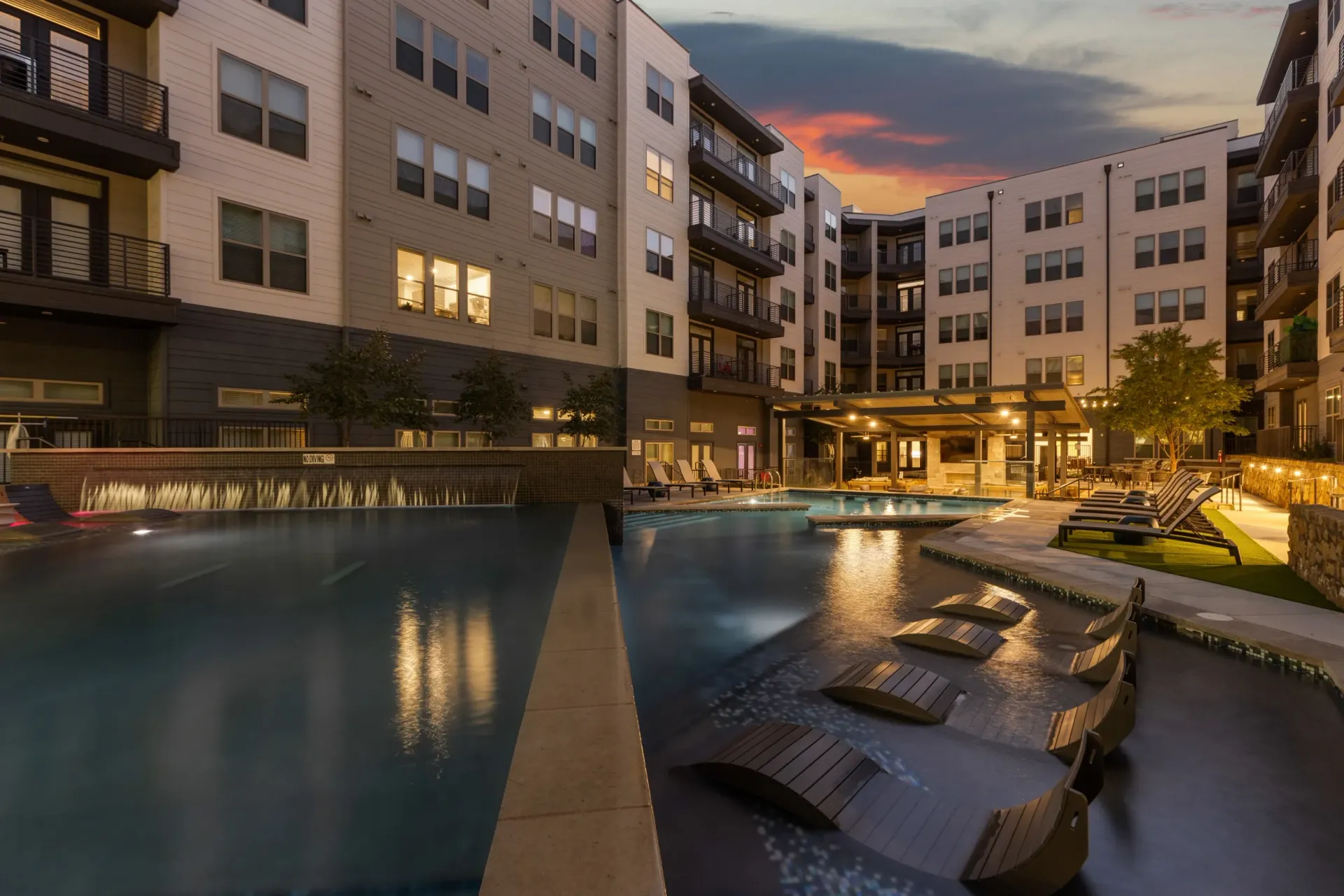 Luxurious pool area with waterfall at dusk