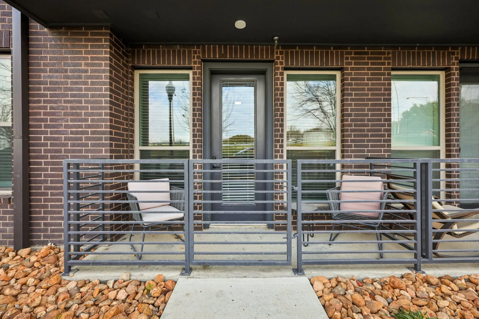 Exterior view of a private balcony with chairs and a small table.