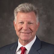 A man in a suit and tie is smiling for the camera.