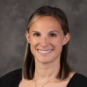 A woman in a black shirt is smiling for the camera.