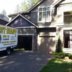 A cleaning service truck parked in front of a house with a garage.
