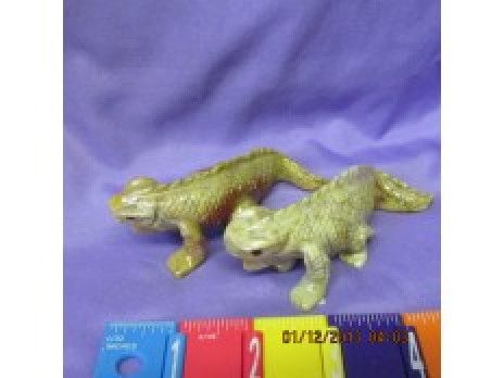 Two small plastic dinosaur toys on purple cloth beside colored measuring blocks