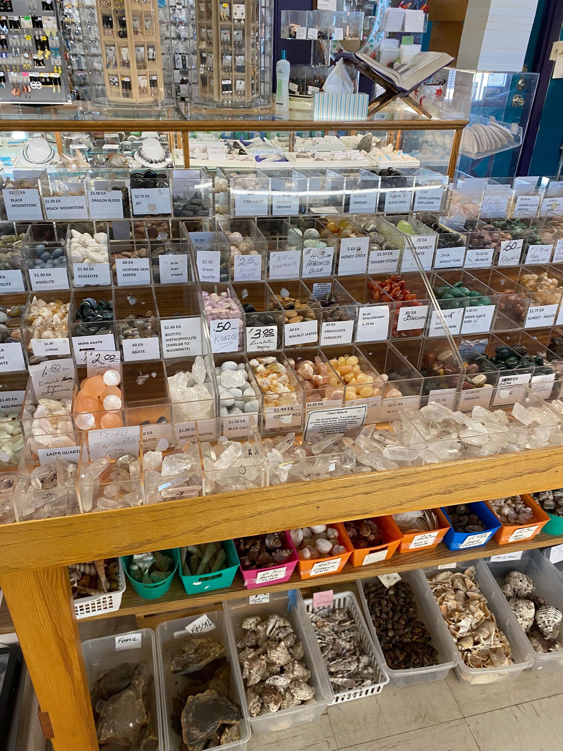 Display of assorted chocolates and sweets in clear containers on shelves in a shop.