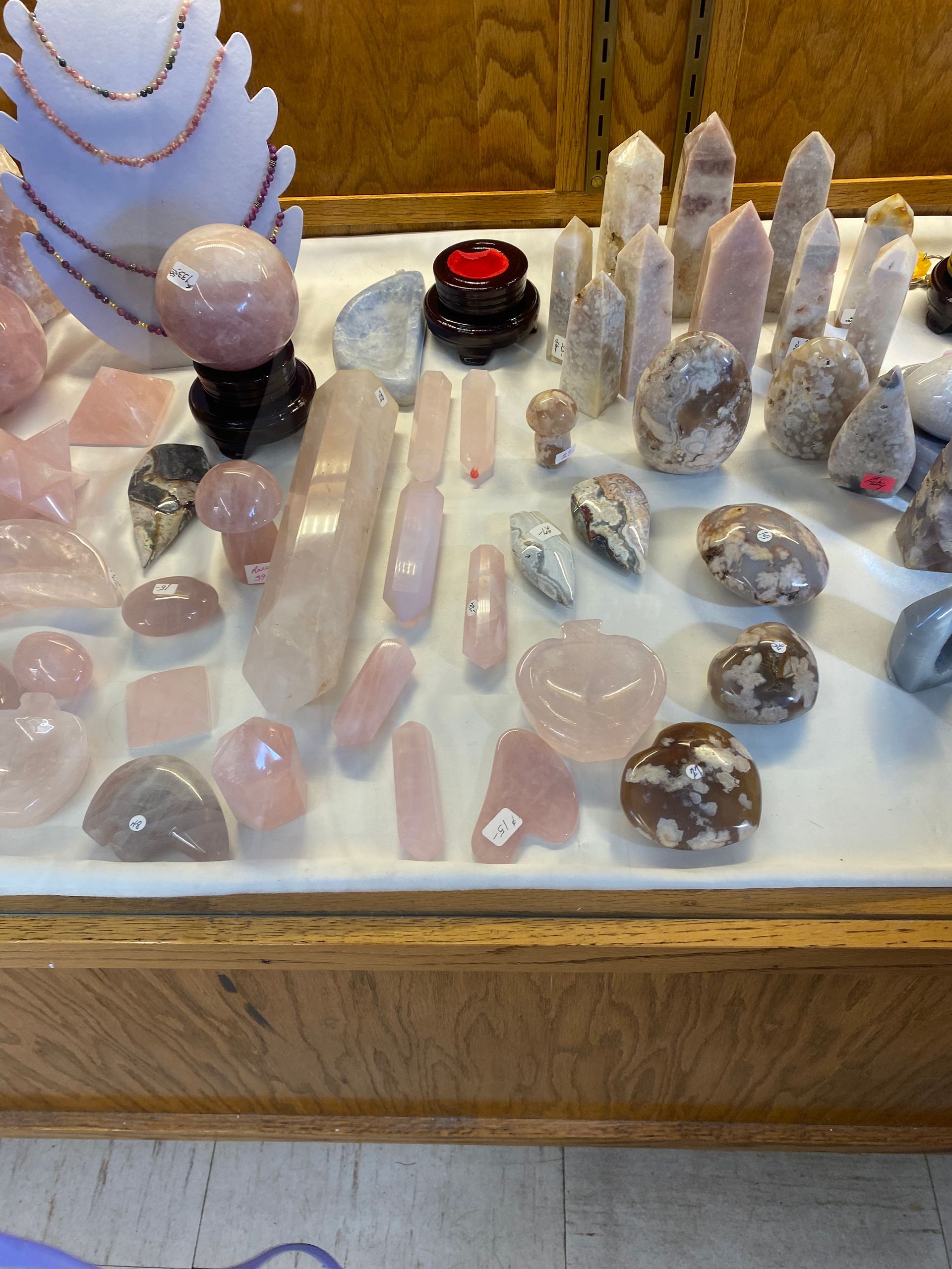Assorted crystals and polished stones displayed on a white tray and wooden surface.