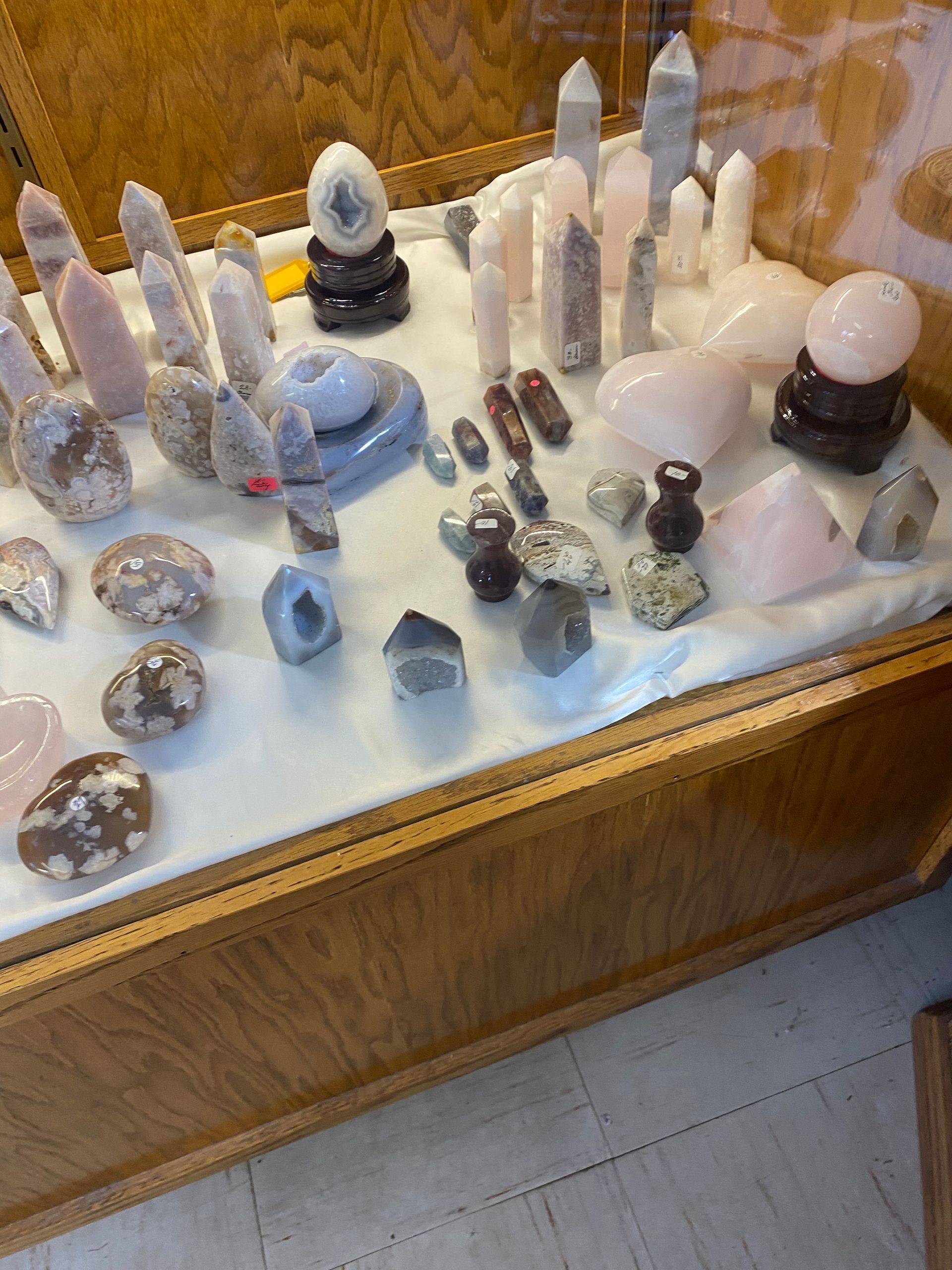 Crystal and mineral specimens displayed on a white tray atop a wooden table.