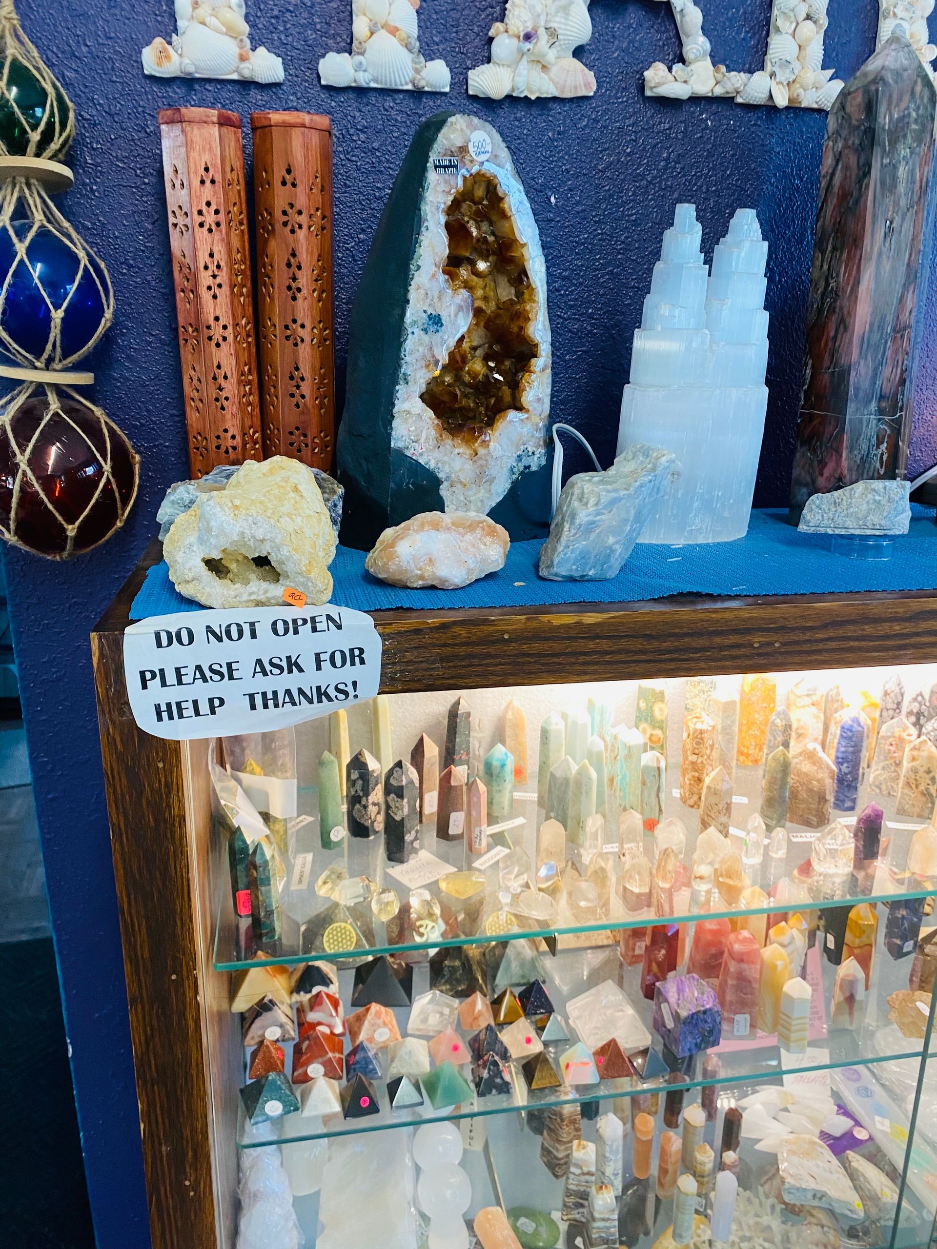 Small crystal and gemstone display with geodes, polished stones, and a glass cabinet of minerals