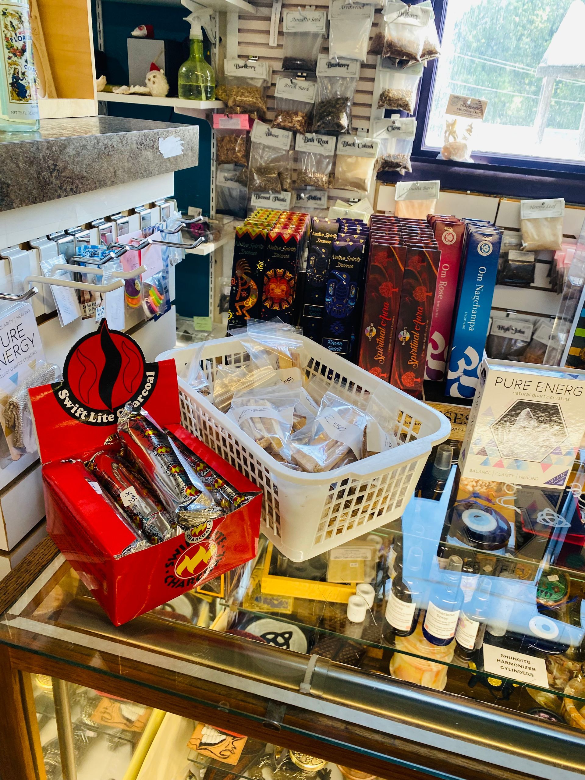 Shop counter with packaged snacks, bottles, and a basket of small items in a cluttered store display