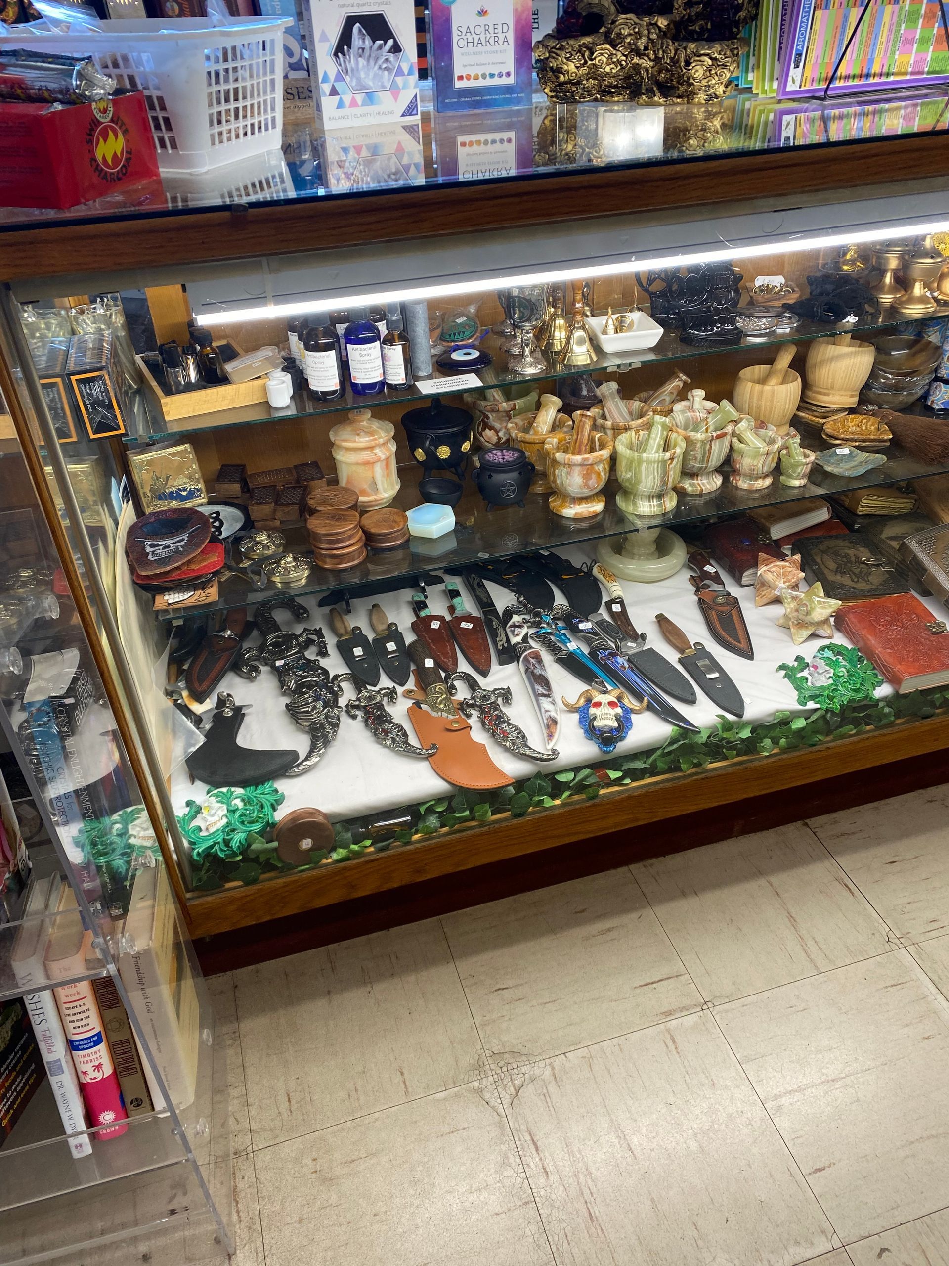 Glass display case of assorted figurines, jewelry, and souvenirs in a shop aisle