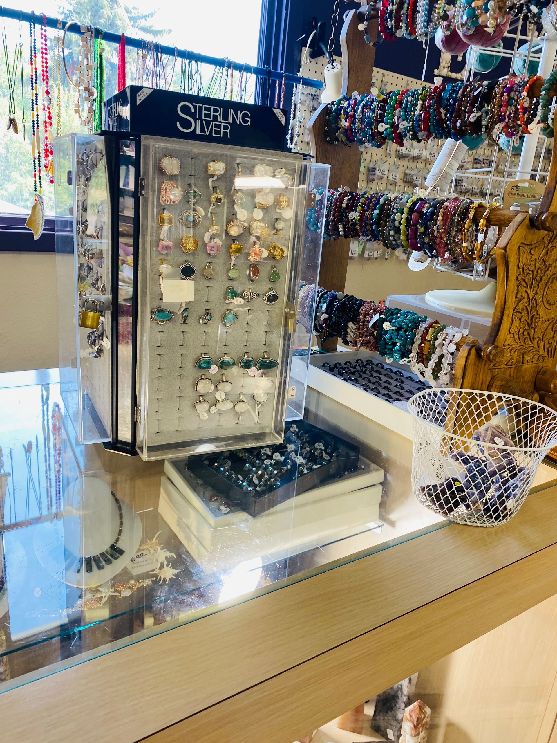 Jewelry display case with colorful necklaces and earrings in a store window
