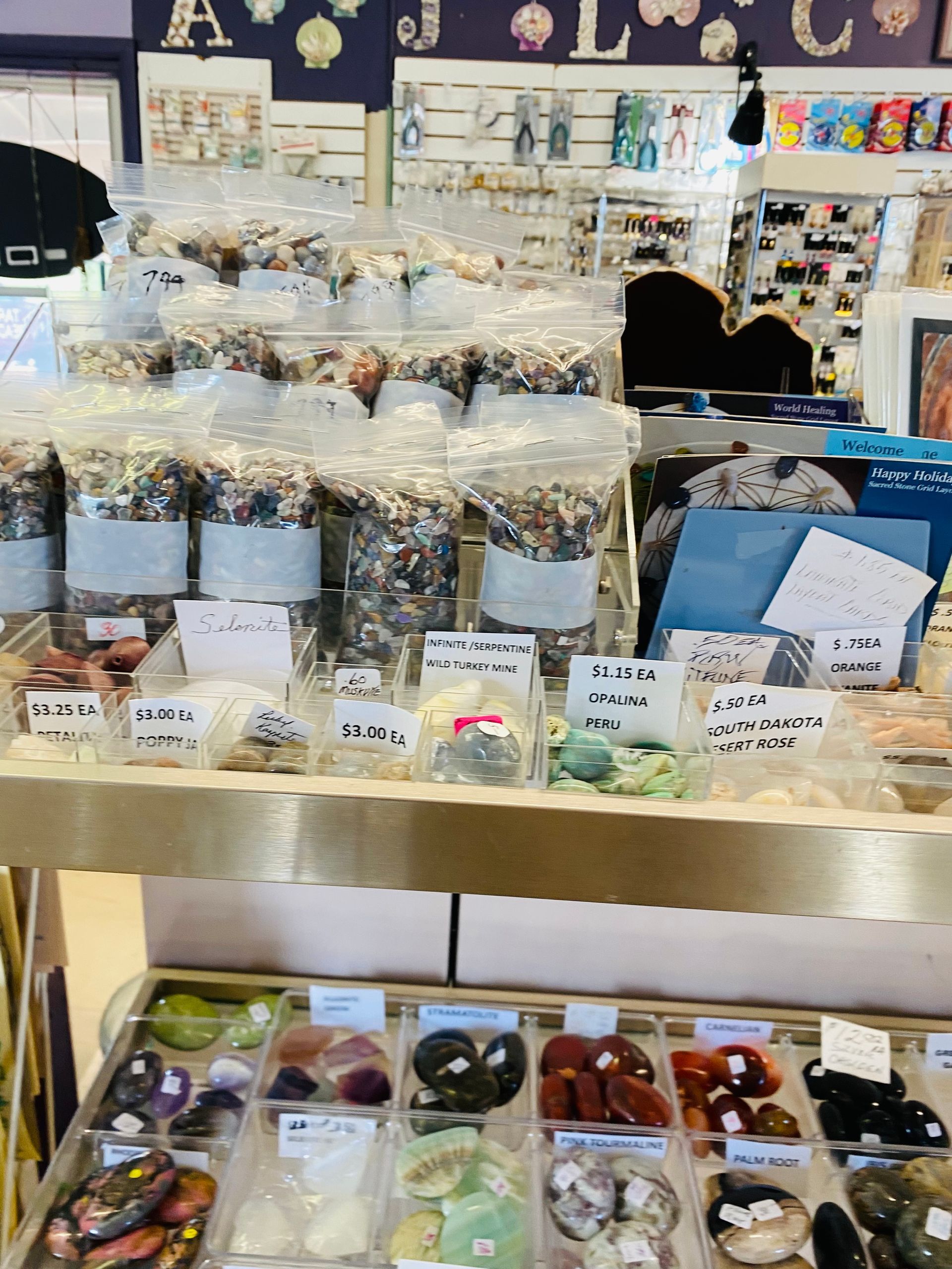 Jarred candles and packaged goods displayed on a shop counter with small labels and colorful items below