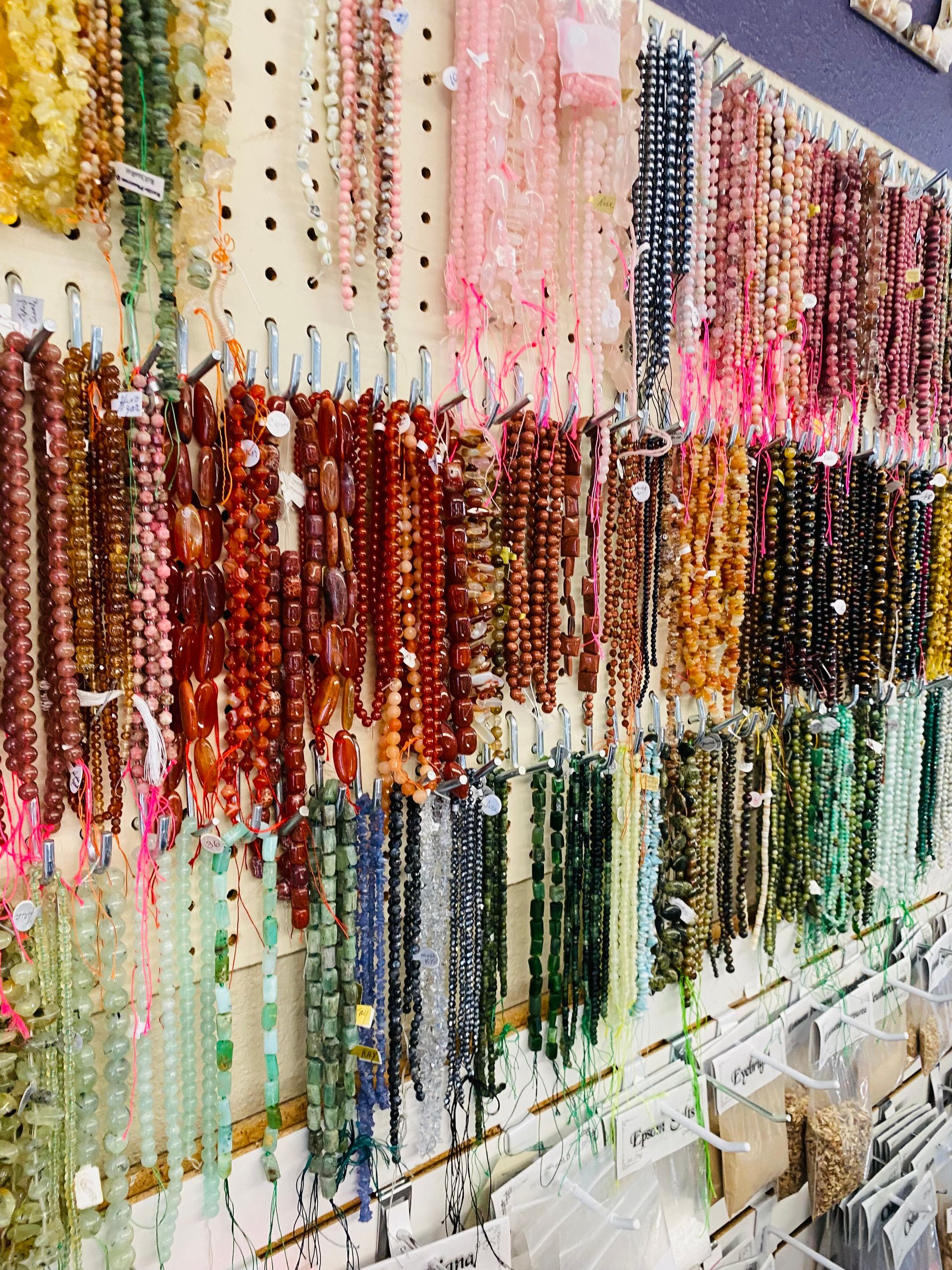 Colorful beaded necklaces hanging in rows at a jewelry market stall