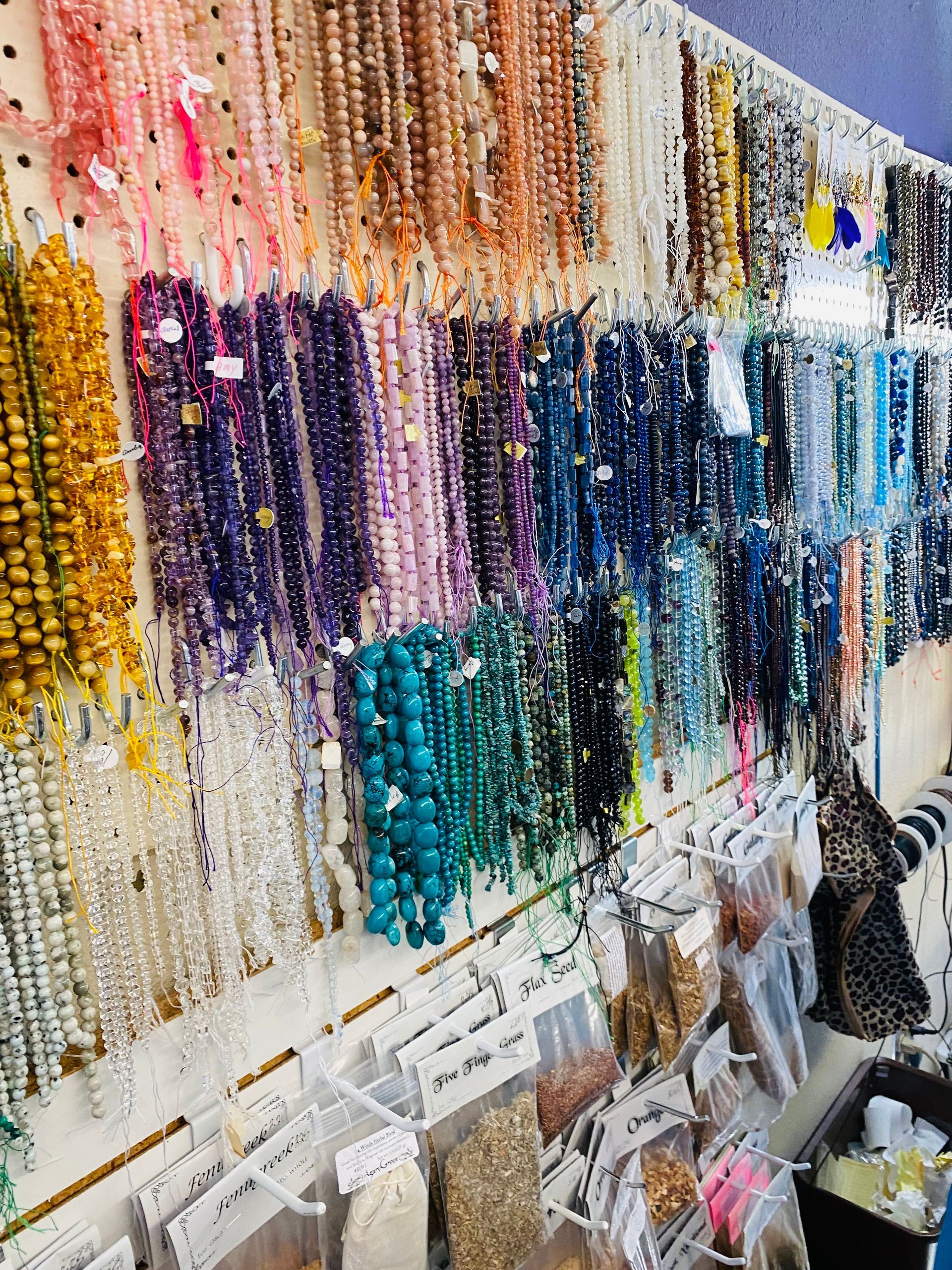 Display of colorful beaded necklaces hanging in rows at a jewelry stall