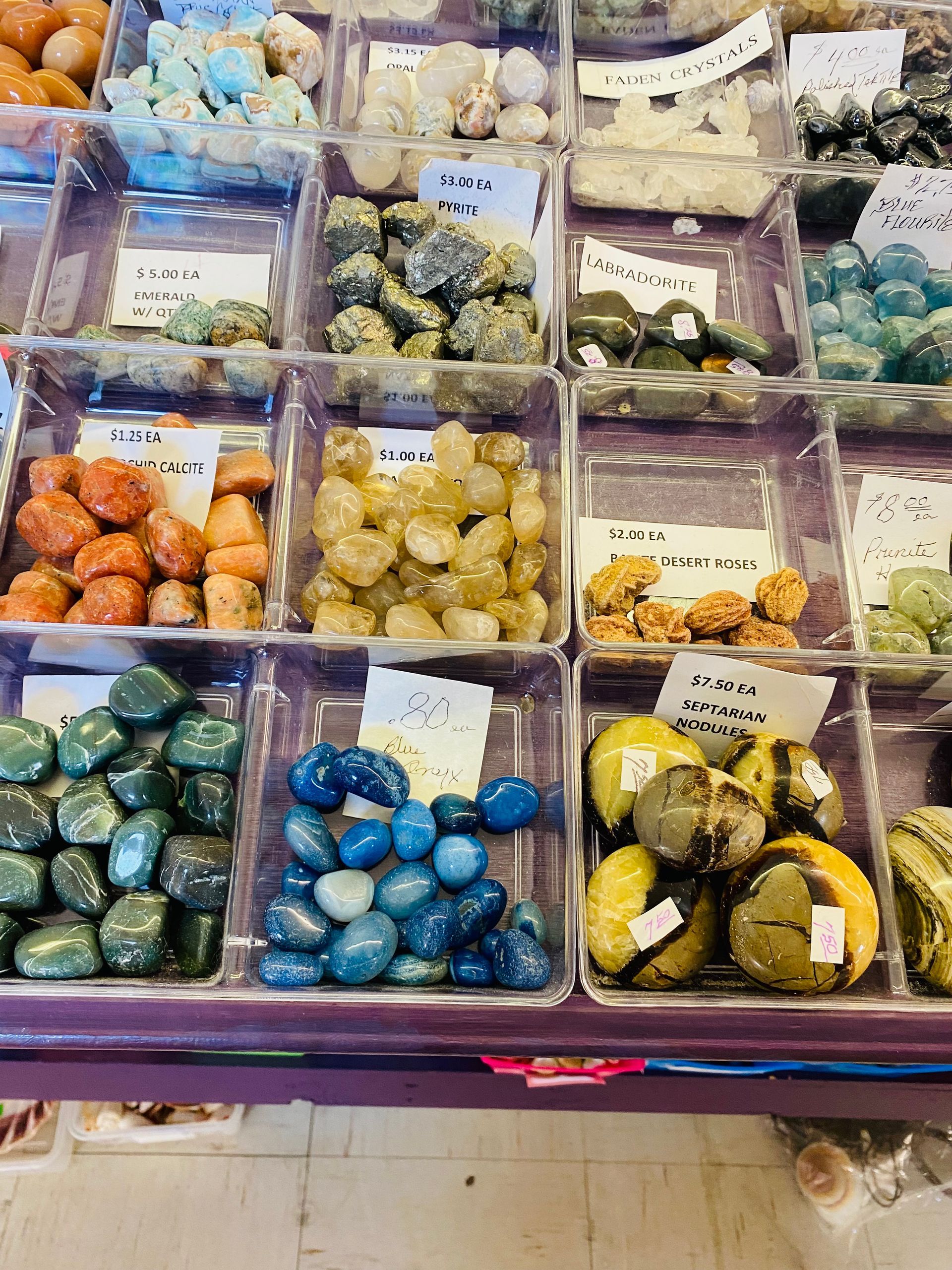 Assorted colorful packaged sweets in clear bins at a market stall