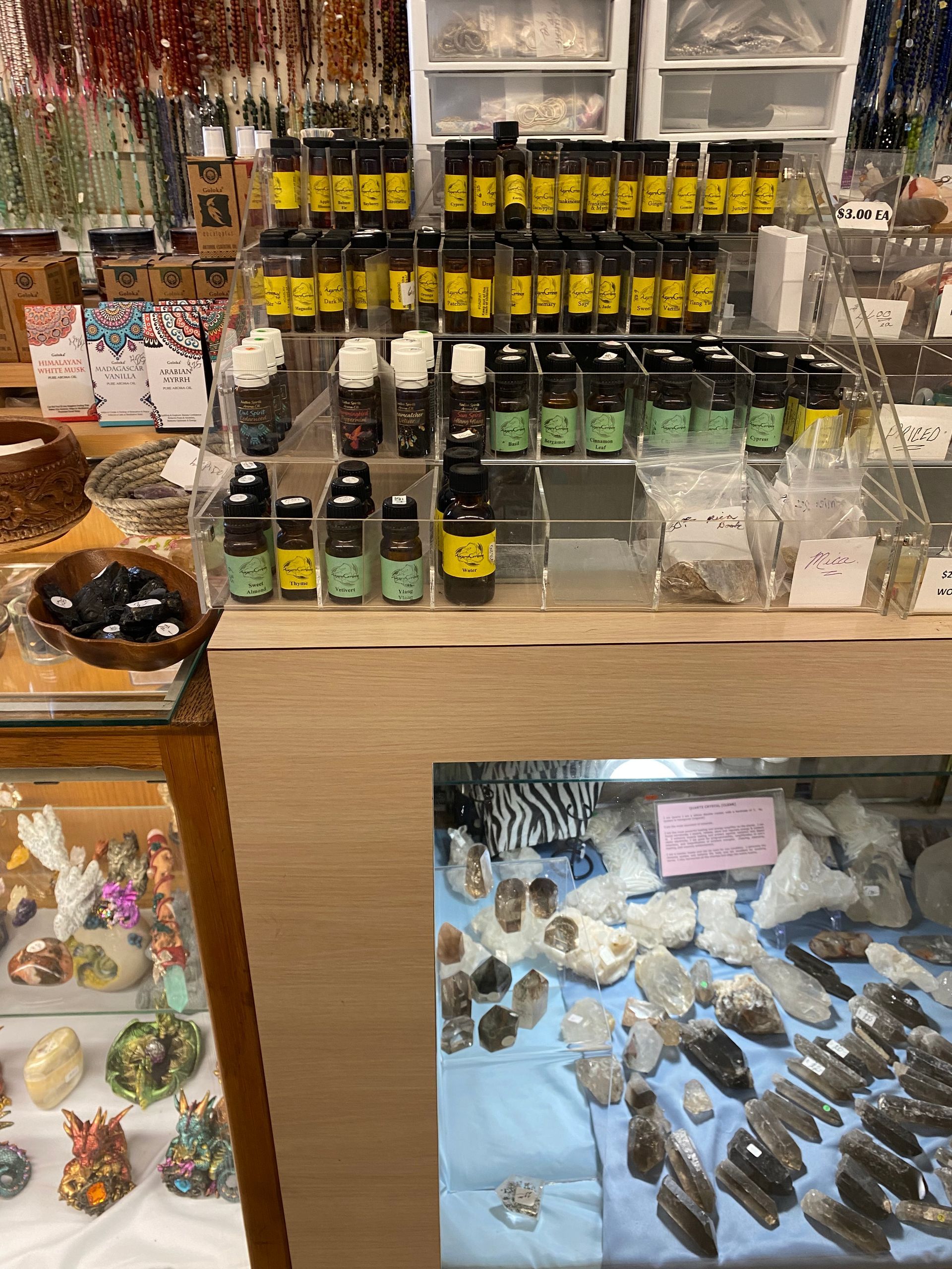 Market stall with shelves of small bottles, trinkets, and colorful jewelry displays