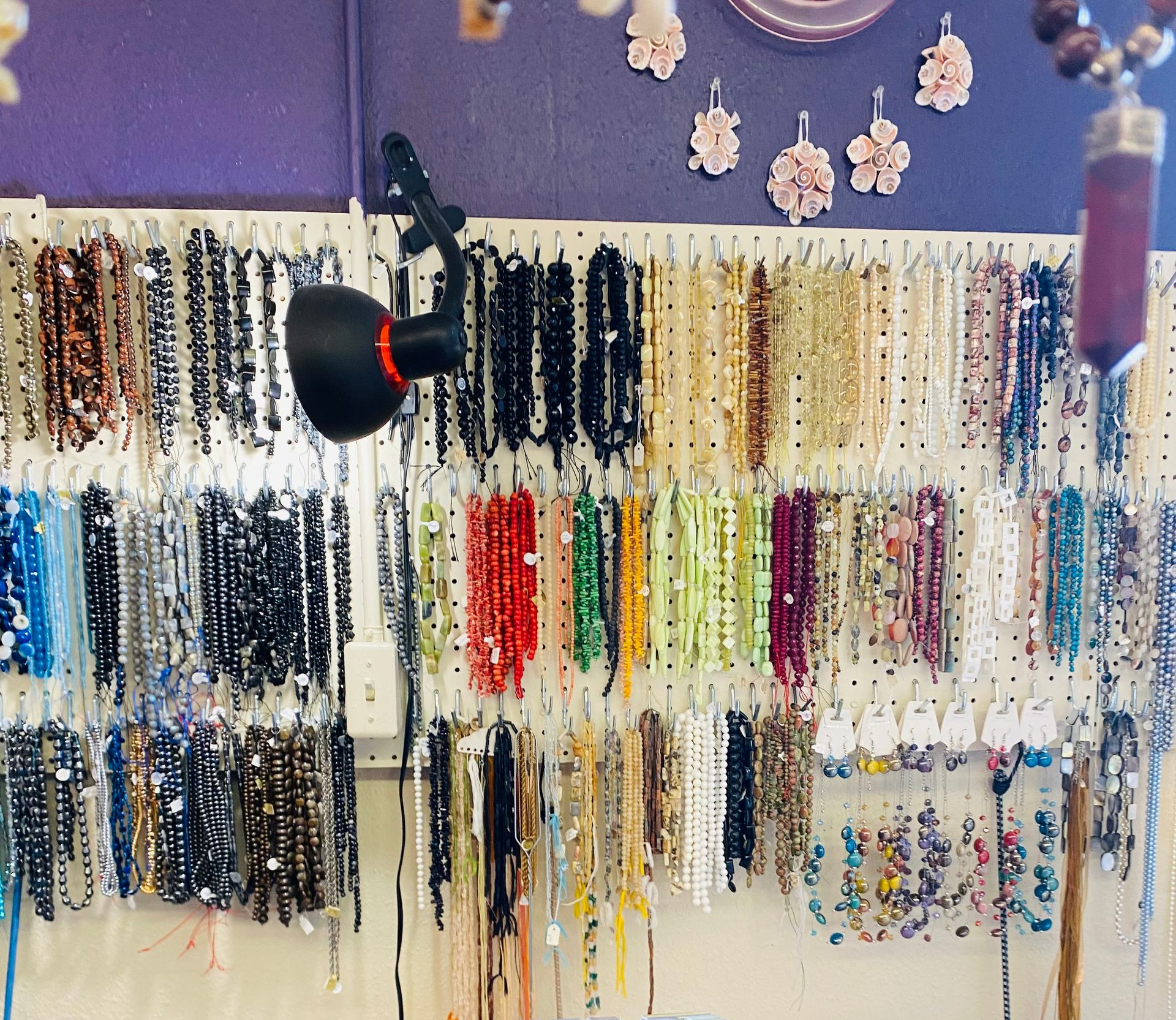 Display case with hanging eyeglass frames in a shop, with a large black machine in the foreground