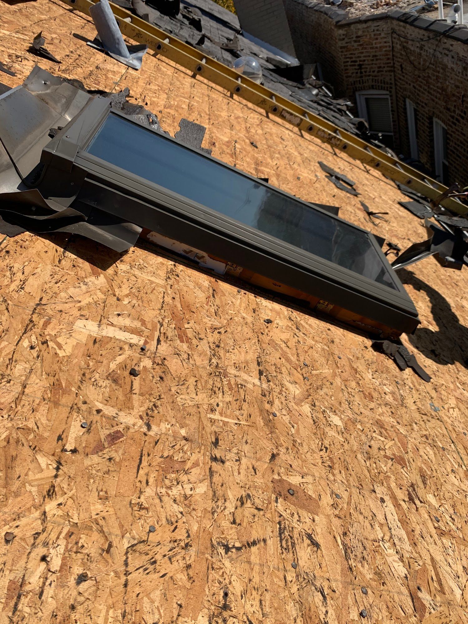 Solar panel lying on a plywood roof under construction, viewed from above.