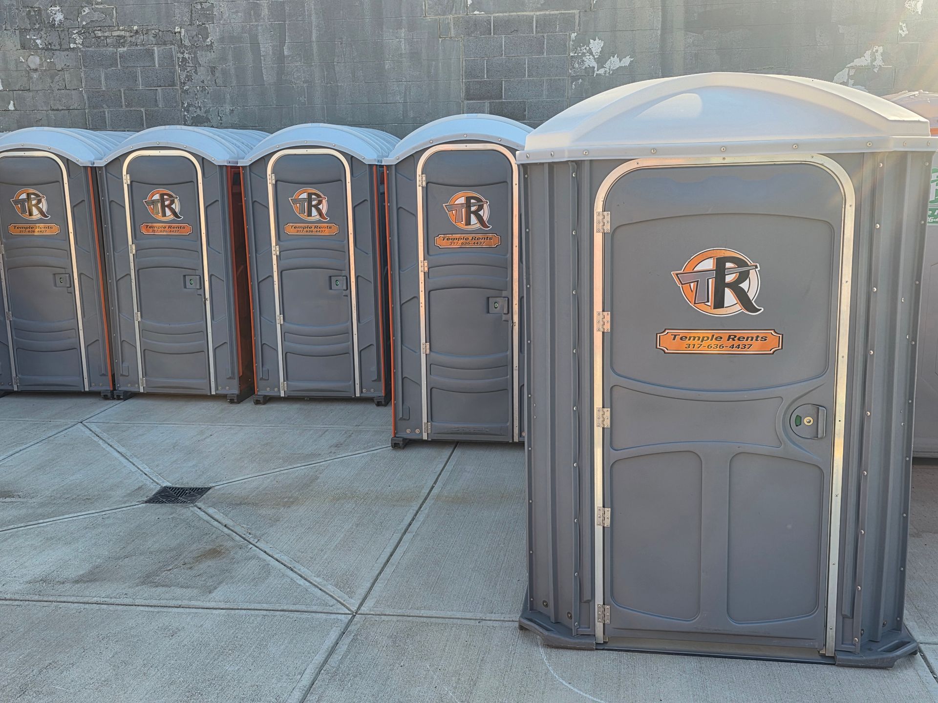 Row of standard and ADA-compliant portable toilet units on an Indianapolis job site