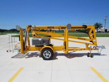Telescoping boom lift raised alongside a warehouse exterior — manlift rental Indianapolis Indiana