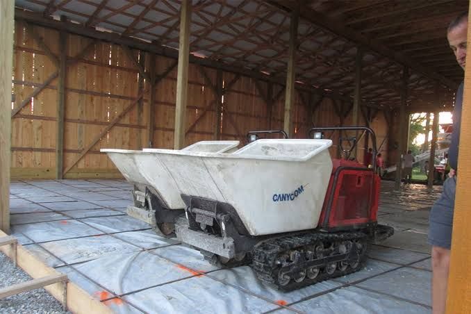 Concrete equipment rental Indianapolis – workers using a concrete vibrator during a slab pour.