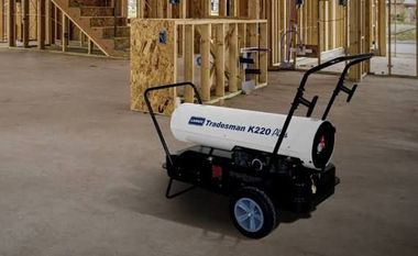 Propane construction heater operating inside a partially framed building in winter — heater rental Indianapolis Indiana