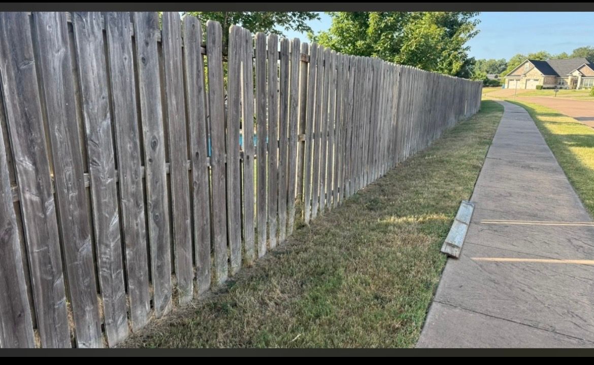 fading wood  fence with loose posts leaning 