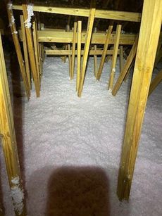 There is a lot of insulation in the attic of a house.