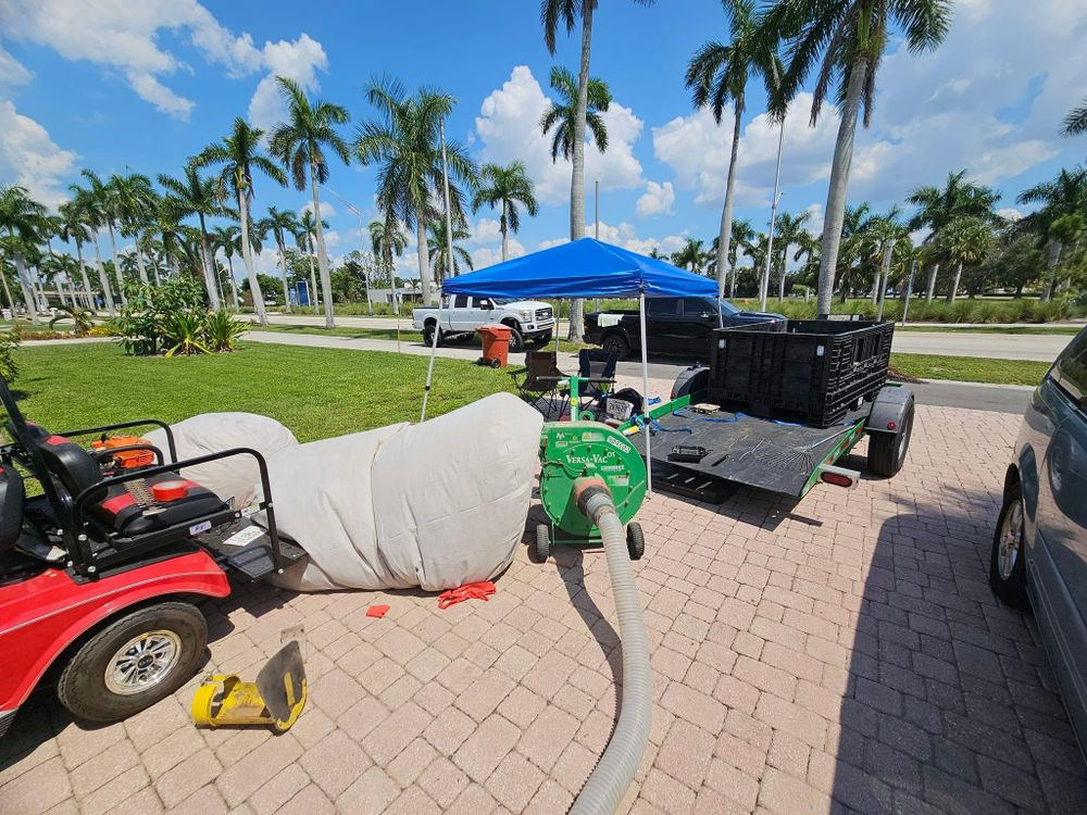 A lawn mower is parked in a driveway next to a trailer.