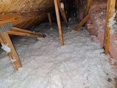 There is a lot of insulation in the attic of a house.