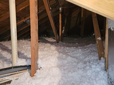 There is a lot of insulation in the attic of a house.