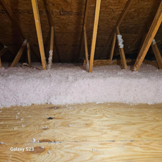 There is a lot of insulation in the attic of a house.