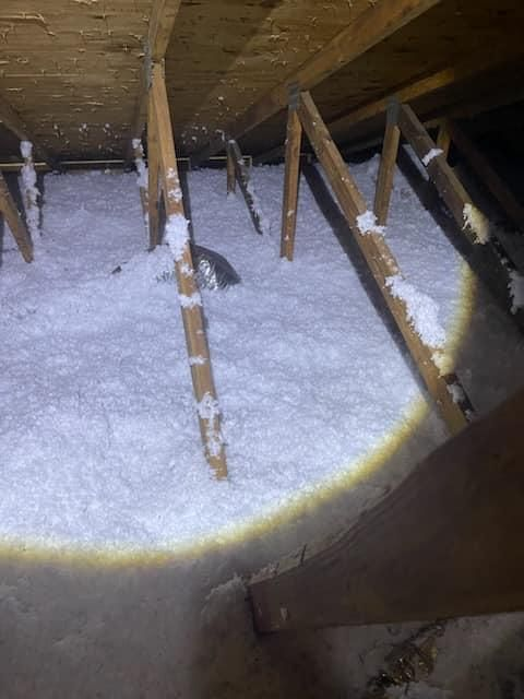 There is a lot of insulation in the attic of a house.