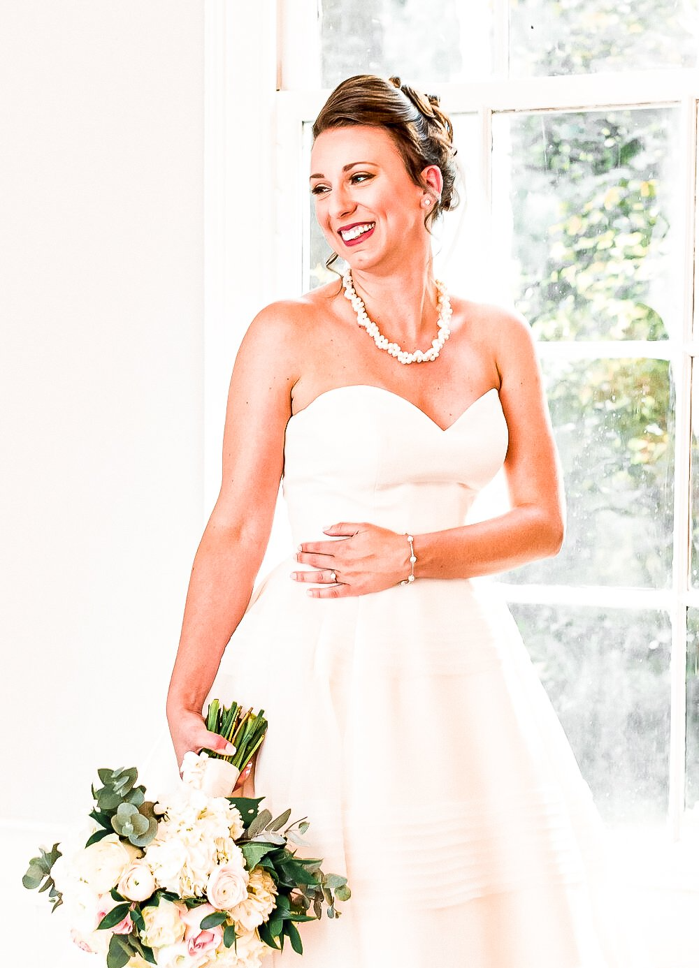 A woman in a wedding dress is holding a bouquet of flowers.