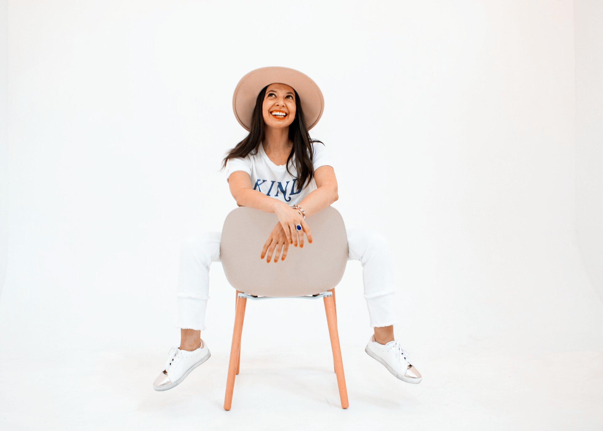 A woman in a hat is sitting on a chair.