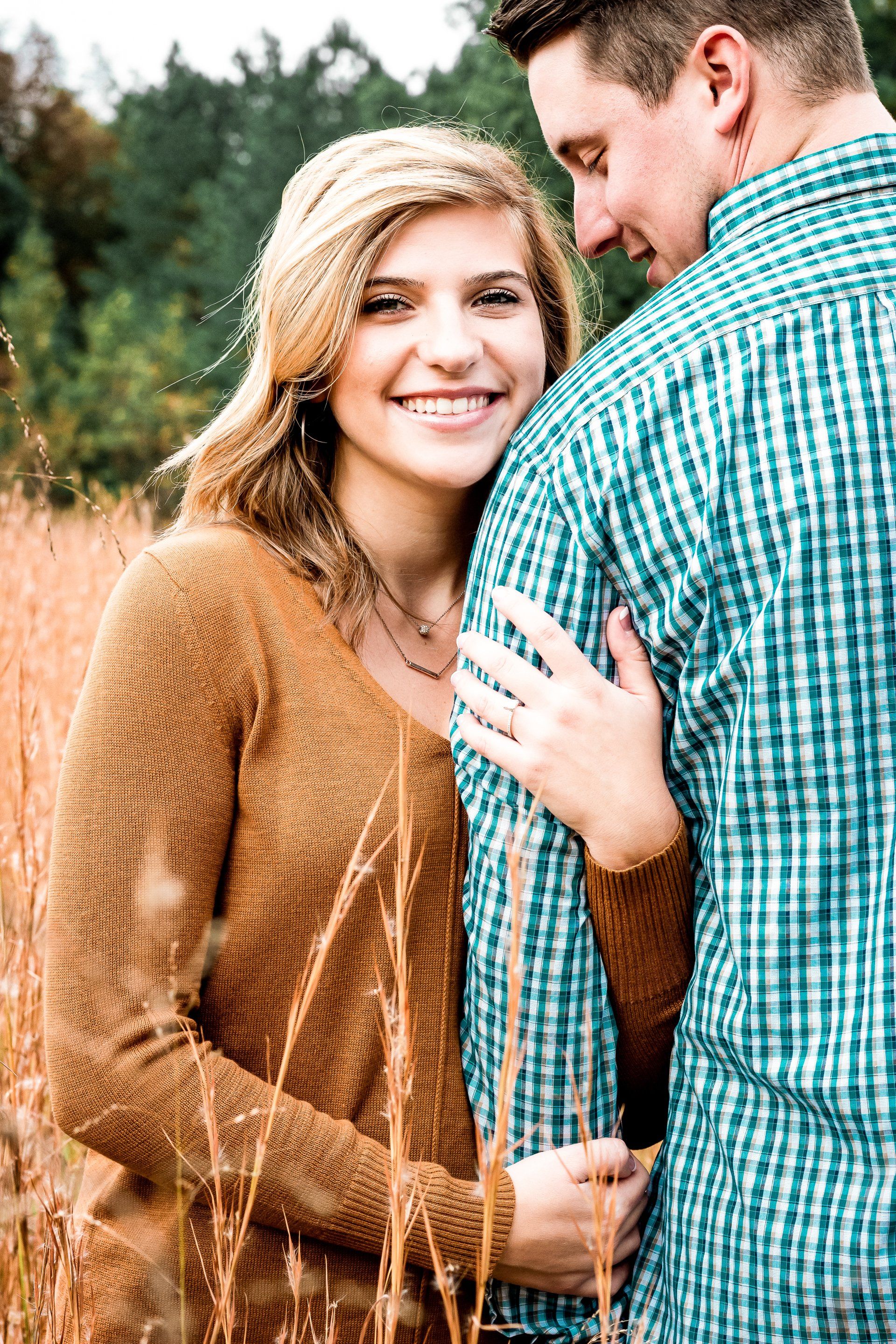 A man and a woman are standing next to each other in a field.