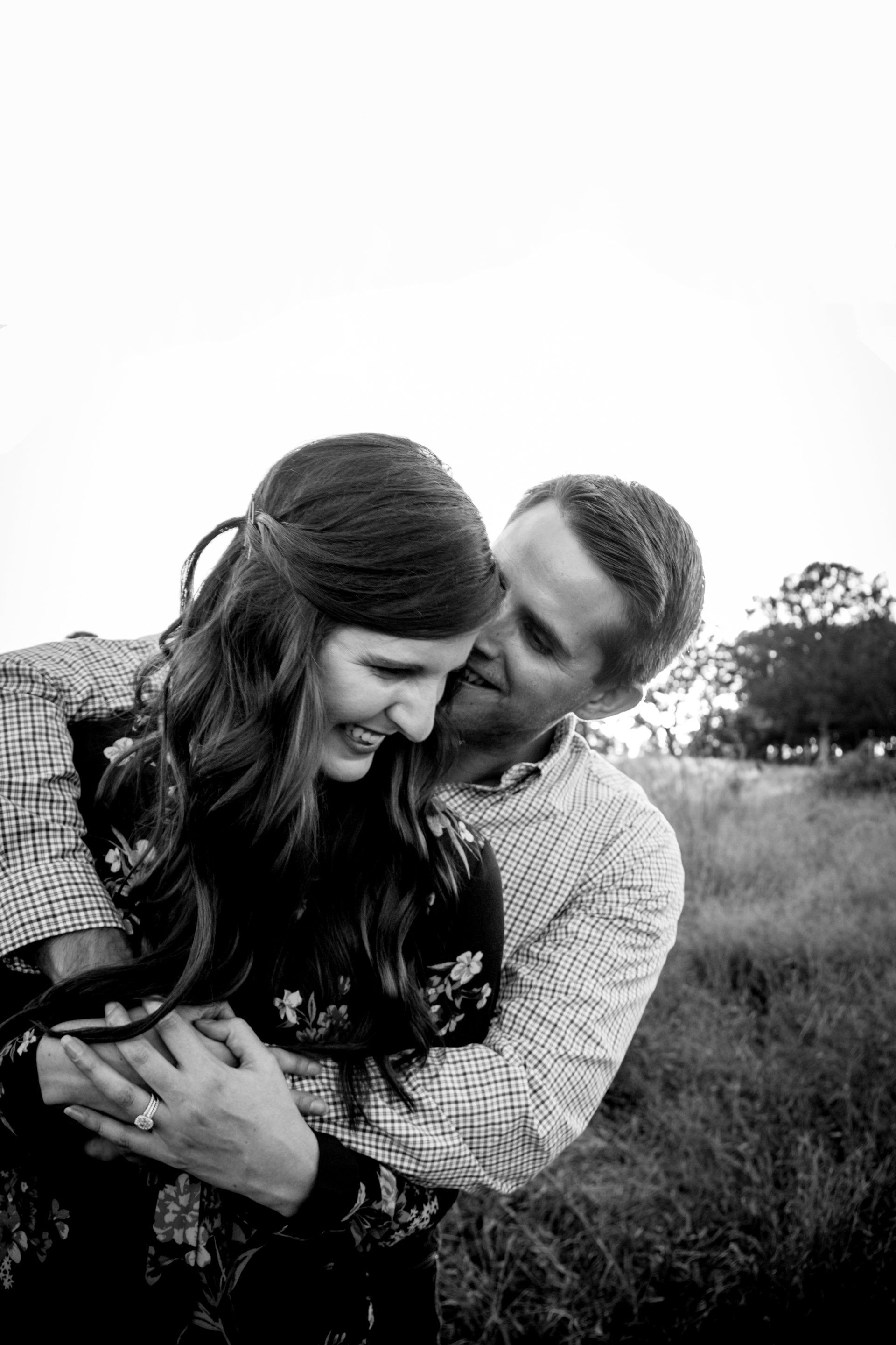 A man is kissing a woman on the cheek in a black and white photo.