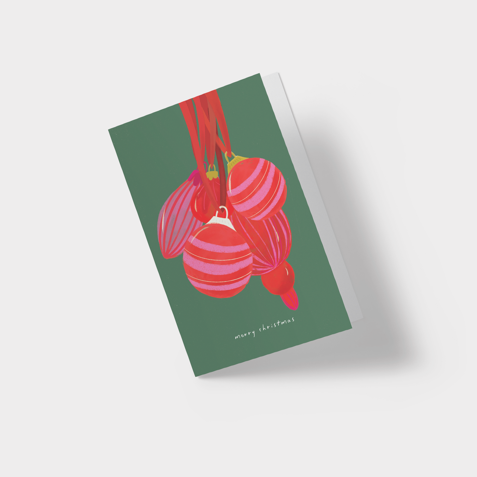 A christmas card with red and pink ornaments hanging from a red ribbon