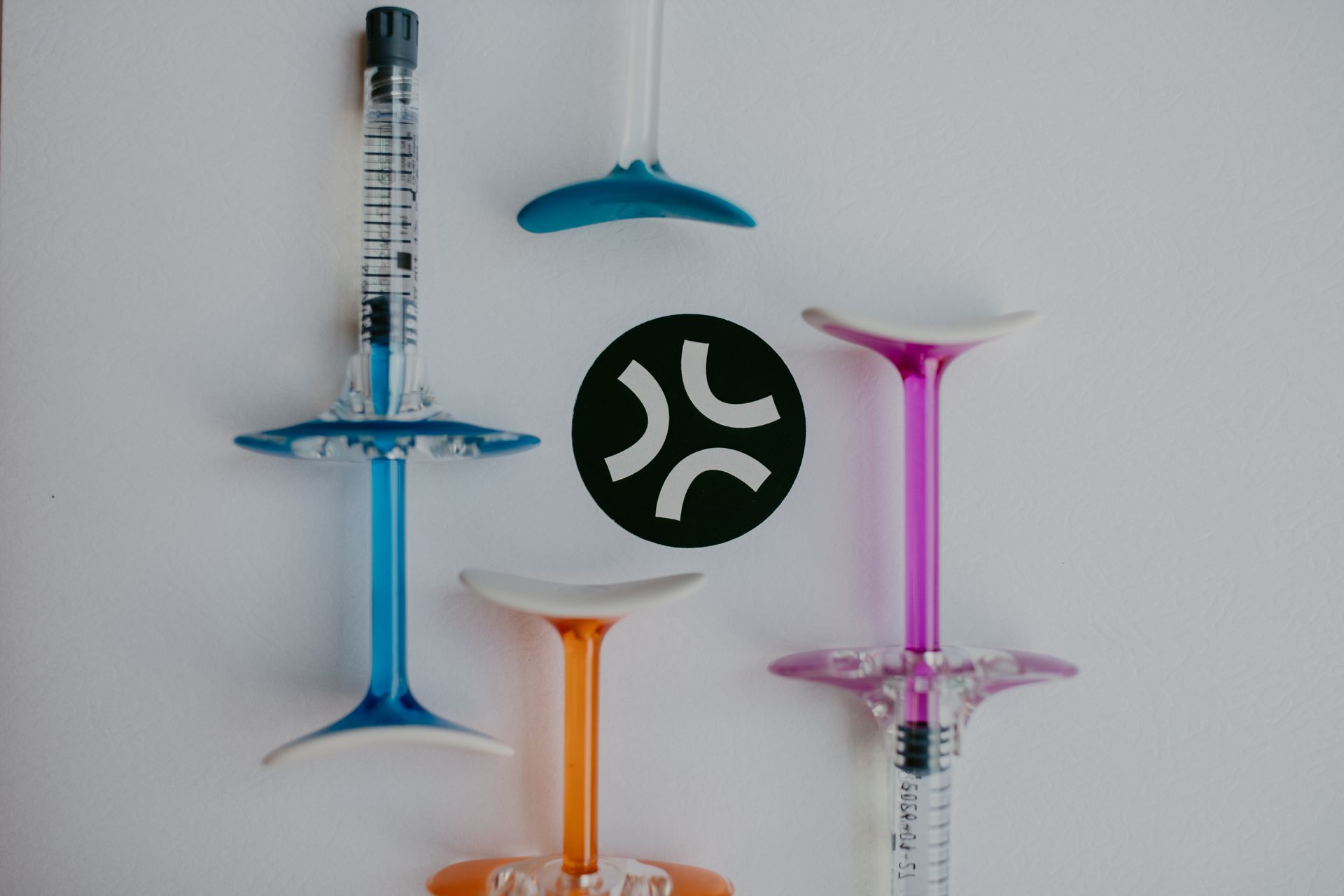 Colorful syringes with angled stands on a white background.