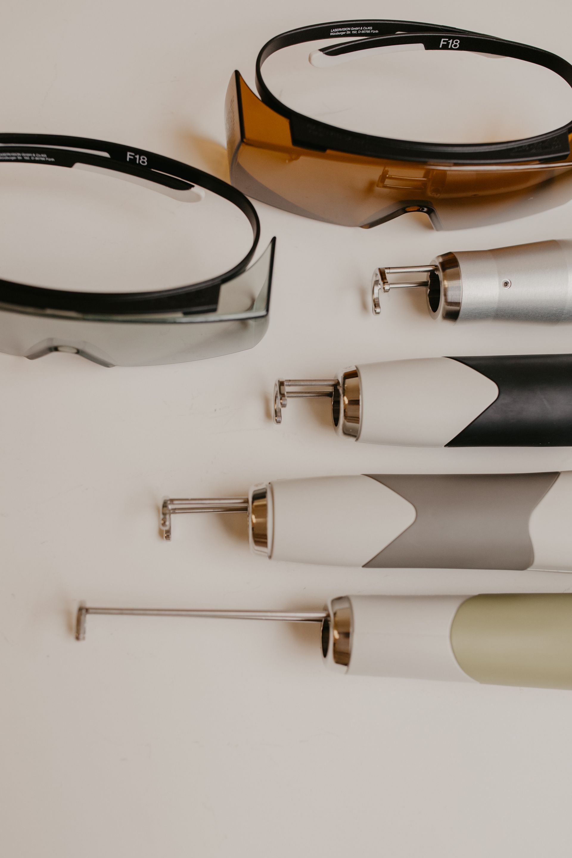 Eyeglasses, pens, and a marker arranged on a white surface