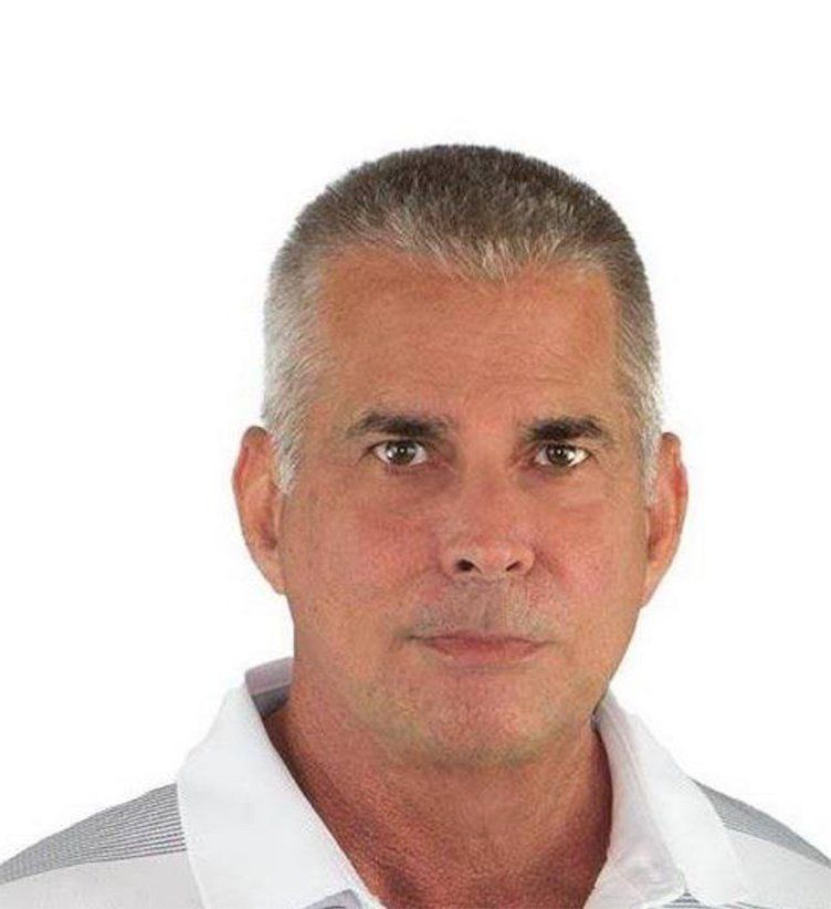 Man with short gray hair wearing a white collared shirt.