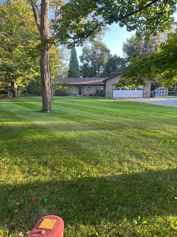 A large house with a garage and a driveway on a rainy day.