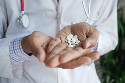 Doctor holding pills in their hands.