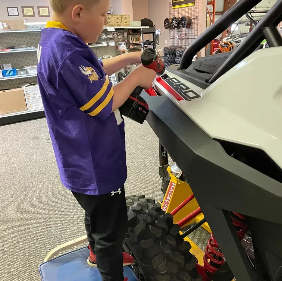 child working on atv
